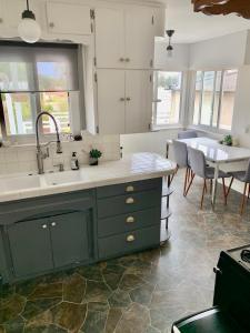 a kitchen with green cabinets and a sink and a table at Quiet3BD2BABikesDeckGarageLaundry in San Pedro