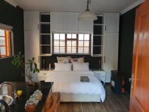 a bedroom with a white bed and a table at Melvilla Studio in Johannesburg