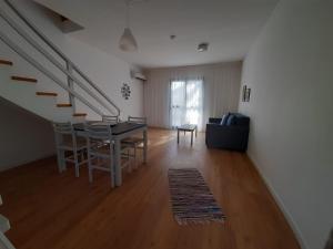 a living room with a table and chairs and a staircase at Hylatio Tourist Village in Pissouri