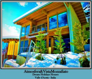 dom z drzewami w śniegu przed nim w obiekcie CHALET con JACUZZI VISTA MONTAGNE w Aoście