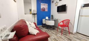 a living room with a red couch and a red chair at Huelintown in Málaga
