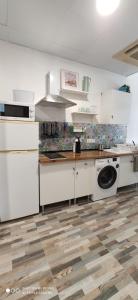 a kitchen with white cabinets and a washing machine at Huelintown in Málaga