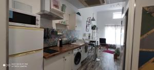 a kitchen with a sink and a washing machine at Huelintown in Málaga