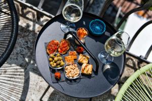a plate of food on a table with wine glasses at Salotto Brè - Bed & Breakfast charming rooms in Lugano