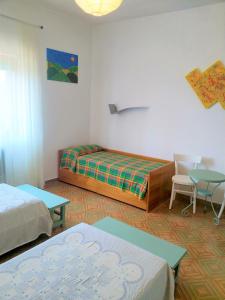 Cette chambre comprend deux lits, une table et des chaises. dans l'établissement Villa Velia Elmo, à Elmo