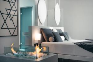 a living room with a bed and a fire place at Emerald Villas & Suites - The Finest Hotels Of The World in Agios Nikolaos