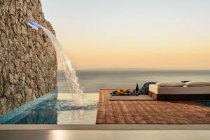 a swimming pool with a bed and a water fountain at Emerald Villas & Suites - The Finest Hotels Of The World in Agios Nikolaos