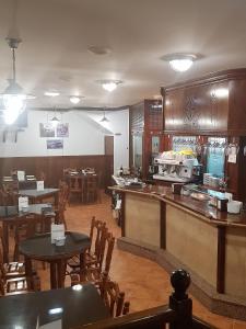 a restaurant with tables and chairs and a kitchen at Hotel La Cuesta in Tapia de Casariego
