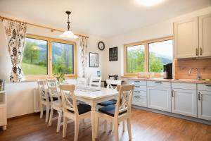 - une cuisine et une salle à manger avec une table et des chaises dans l'établissement Appartement Sonnenheim, à Ramsau am Dachstein