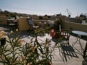 a rooftop patio with chairs and tables and plants at Fiera Guesthouse in Ermoupoli