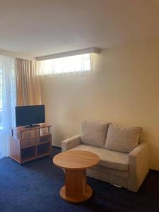 a living room with a couch and a table at Alka Boutique Apartments & SPA in Palanga