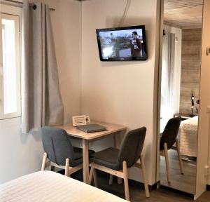 Habitación con mesa con sillas y TV en la pared. en Vuokatti Weekend Studio, en Vuokatti