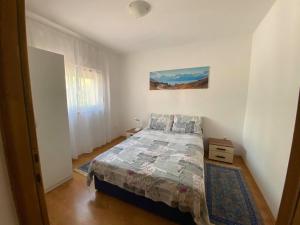 una camera da letto con un letto in una stanza bianca di Renic Apartments a Nin