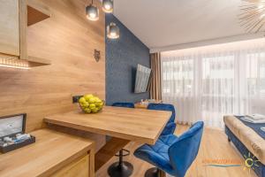 科沃布熱格的住宿－Apartament Kołobrzeski Relax，配有桌子、蓝色椅子和床的房间