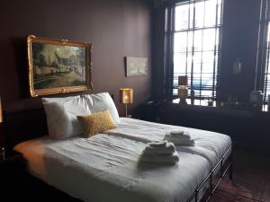 a bedroom with a large bed and a large mirror at Boutique Hotel Zeeuws-Meisje in Zierikzee