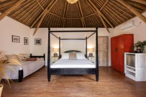 Amahelia Luxury Resort & Restaurant - Gili Asahan في جيلى اساهان: غرفة نوم مع سرير مظلة في غرفة