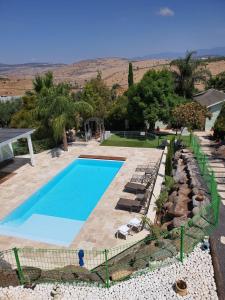 a swimming pool in a yard with chairs and trees at Morad Haharbel - Boutique Resort in Arbel