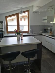 kuchnia z blatem i dwoma krzesłami barowymi w obiekcie Apartement Flörl w mieście Rohrberg +22 zdjęcia