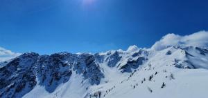 una montagna coperta di neve con un cielo blu di Haus Enzian Apartments a Kartitsch