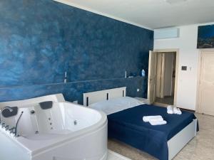 un bagno con vasca e un letto accanto a una vasca. di Suite al mare a Taranto