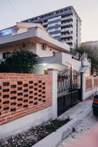 una casa con una recinzione di mattoni e un edificio di Apartments Mehmeti a Vlorë