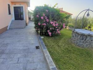 uma passagem que leva a uma casa com flores cor-de-rosa em Apartment Nona Nina em Koper