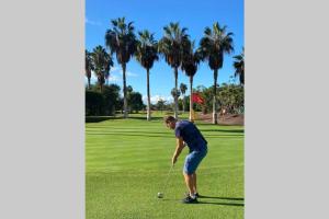 un hombre está jugando golf en un campo de golf en Casa Reinhart sehr schönes Apartment um Teneriffa zu erkunden, en Palm-mar