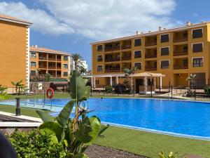 una gran piscina frente a un edificio en Casa Reinhart sehr schönes Apartment um Teneriffa zu erkunden, en Palm-mar