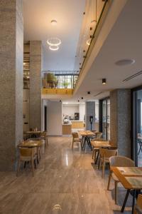 a dining room with wooden tables and chairs at Hyperion City Hotel & Spa in Chania