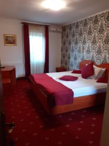 a hotel room with a large bed with red sheets at Pension Lion in Sibiu