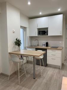 a kitchen with a wooden table and white cabinets at Puntos cardinales in Los Corrales de Buelna