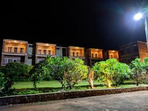 un edificio de noche con árboles delante en Kanthi Resorts Badami en Bāgalkot