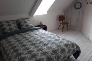 a bedroom with a bed and a chair at A bon port Grandcamp-Maisy in Grandcamp-Maisy