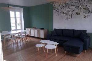 a living room with a couch and a table and chairs at A bon port Grandcamp-Maisy in Grandcamp-Maisy