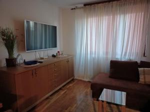 a living room with a television on top of a dresser at Walk Apartment in Vukovar +19 photos