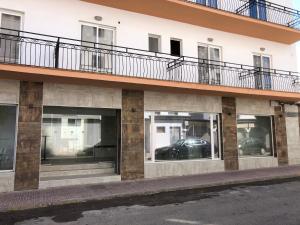 a building with multiple windows with a car in it at Hostal Rosalia in San Antonio
