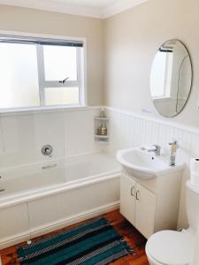 Casa Surf Lodge J'Bay في خليج جيفريز: حمام مزود بحوض استحمام ومغسلة ومرآة +34 صورة