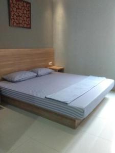 a bedroom with a large bed with a wooden headboard at 5Residence in Jatingaleh