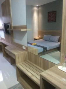 een slaapkamer met een bed en een spiegel in een kamer bij 5Residence in Jatingaleh