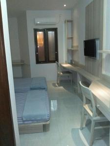 ein Krankenhauszimmer mit einem Bett, einem Schreibtisch und Stühlen in der Unterkunft 5Residence in Jatingaleh