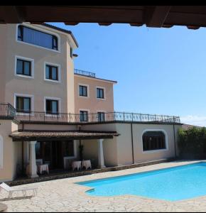 une villa avec une piscine en face d'un bâtiment dans l'établissement Le Tre Rose, à Bono