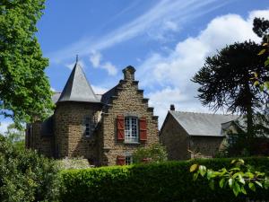 una vieja casa de ladrillo con una torreta en Villa La Côte du Chat 3* en Bretagne romantique, en Hédé