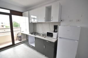 a kitchen with a white refrigerator and a microwave at Casa Roma in Mamaia Nord
