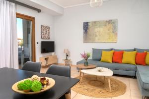 a living room with a blue couch and a table at Calma Guest House in Ierissos