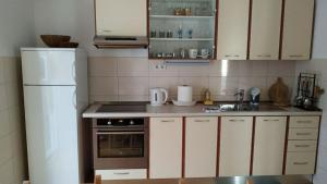a kitchen with white cabinets and a white refrigerator at Apartment Kate in Omiš