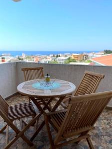 巴尔Apartmani Rajkovic的阳台上的一张桌子、两把椅子和一个杯子