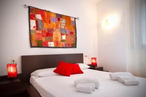 a bedroom with a red pillow and two towels on a bed at Villa Cedrino in San Teodoro