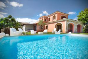 a villa with a swimming pool in front of a house at Villa Cedrino in San Teodoro