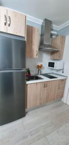a kitchen with a stainless steel refrigerator and wooden cabinets at Green Park in San Miguel de Abona