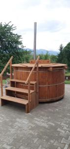 a wooden structure with a hot tub and a wooden fence at Conacul lui Radu in Făgăraş